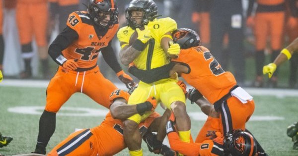 CJ Verdell surrounded_Karl Maasdam of OSU Athletics.jpg